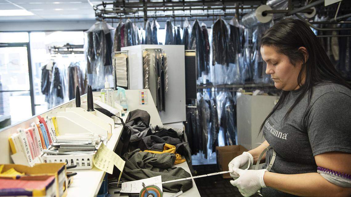 Cynthia Bastardo tags clothing at Bonded Cleaners in Modesto, Calif., on Thursday, April 2, 2020.