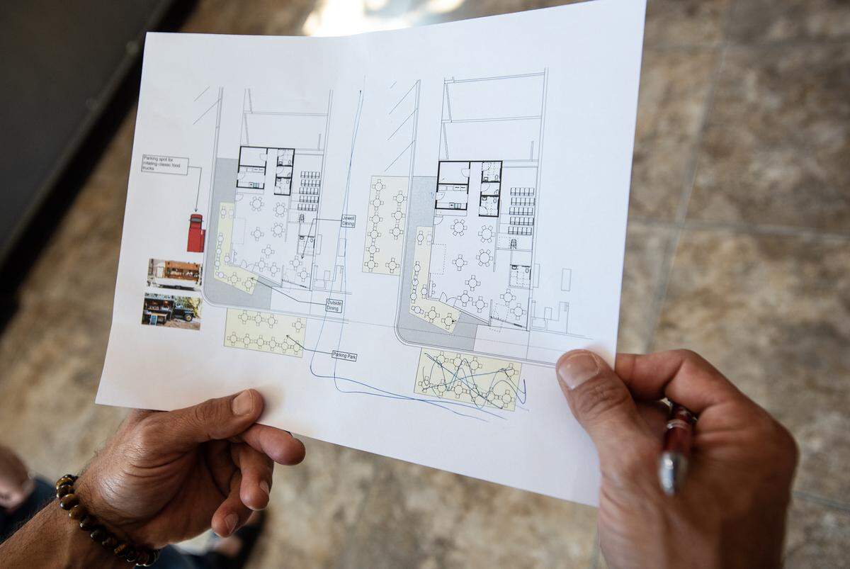 State Theatre board member Sam Pierstorff holds a preliminary drawing of the theater’s expansion into the space vacated by Money Mart on the corner of 13th and J Streets in Modesto, Calif., on Friday, May 13, 2022.