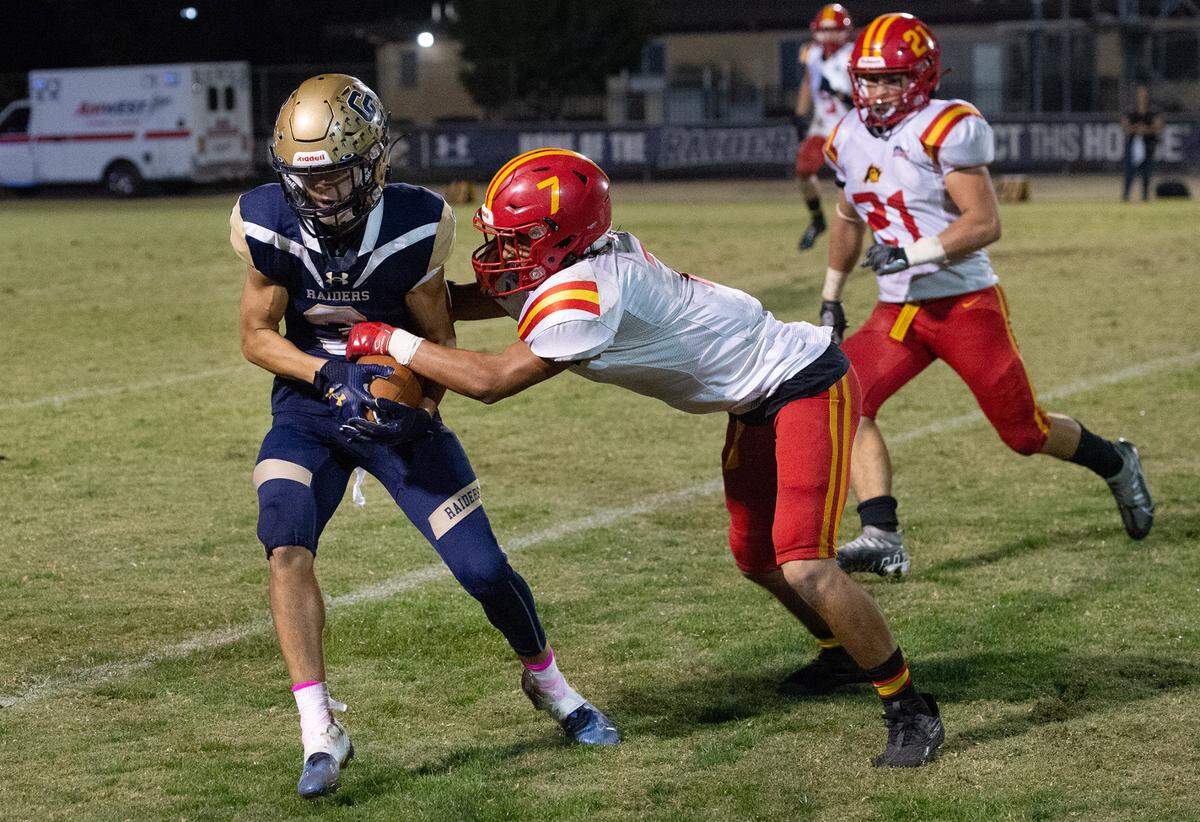 Central Catholic’s Trace Hernandez holds on to the ball as he grapples with Oakdale’s Mauricio Pena during the Valley Oak League game in Modesto, Calif., Friday, Oct. 14, 2022.