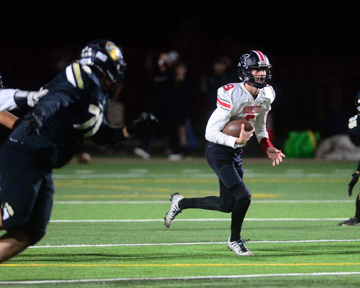 Modesto High quarterback Eli McCabe scrambles upfield during a game against Enochs at Johansen High School in Modesto, Calif., on Oct. 28, 2022.