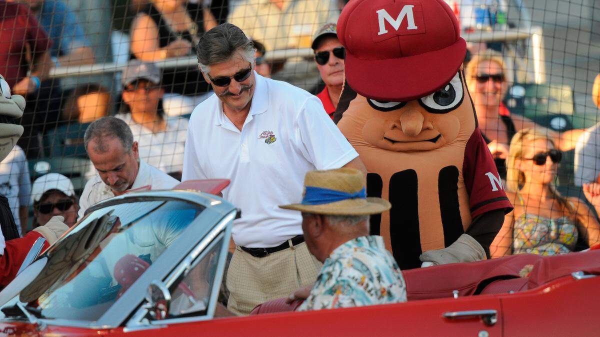 Rollie Fingers, after making an entrance in a red Mustang convertible, is greeted by a Modesto Nuts mascot during the California Carolinas All Star Smash at Thurman Field on June 21, 2011.