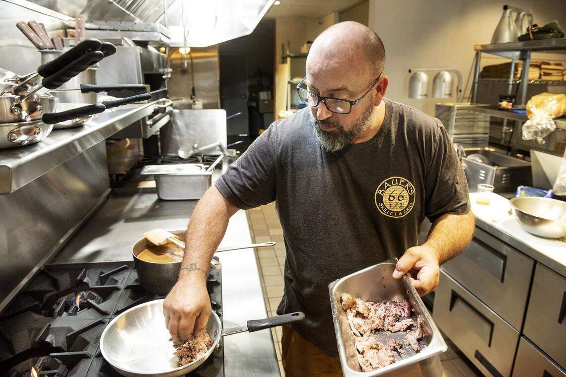 Chef Tye Bauer creates a duck confit sandwich at Bauer’s Downtown Gastropub in Modesto, Calif., Wednesday, Nov. 27, 2019.