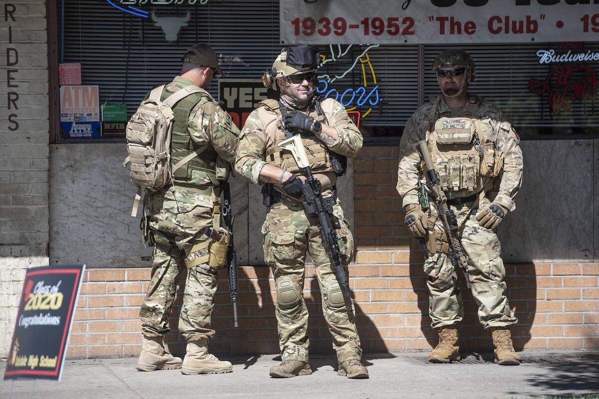 Members of the California State Militia stand outside the H-B Saloon on Highway 120 in Oakdale, Calif., on Saturday, June 6, 2020.