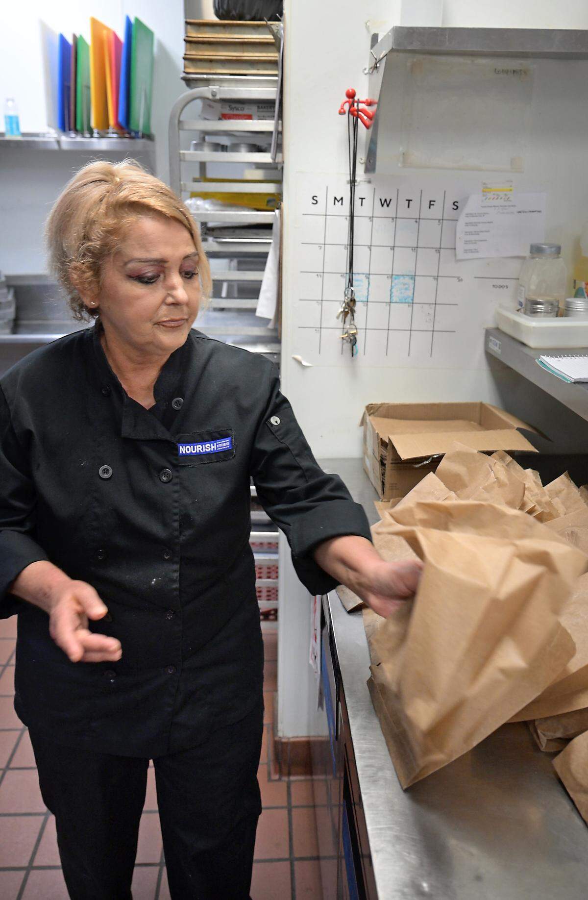Nourish Kitchen job readiness program participant Michelle Camarata packages cookies for the food truck inside the kitchen at Turlock Gospel Mission in Turlock.