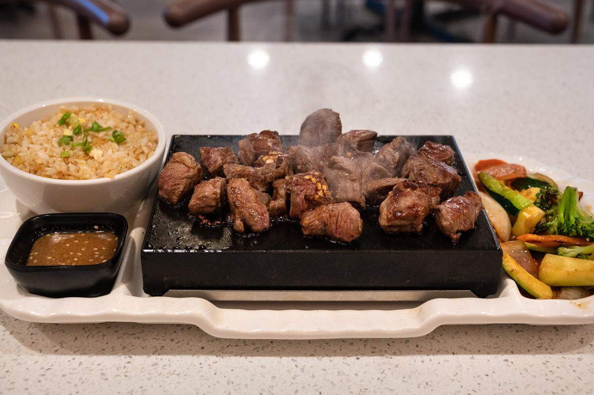 Rib eye steak is kept warm on a hot volcano stone at Okawa Sushi & Grill on Oakdale Road in Modesto, Calif., Thursday, September 29, 2022.