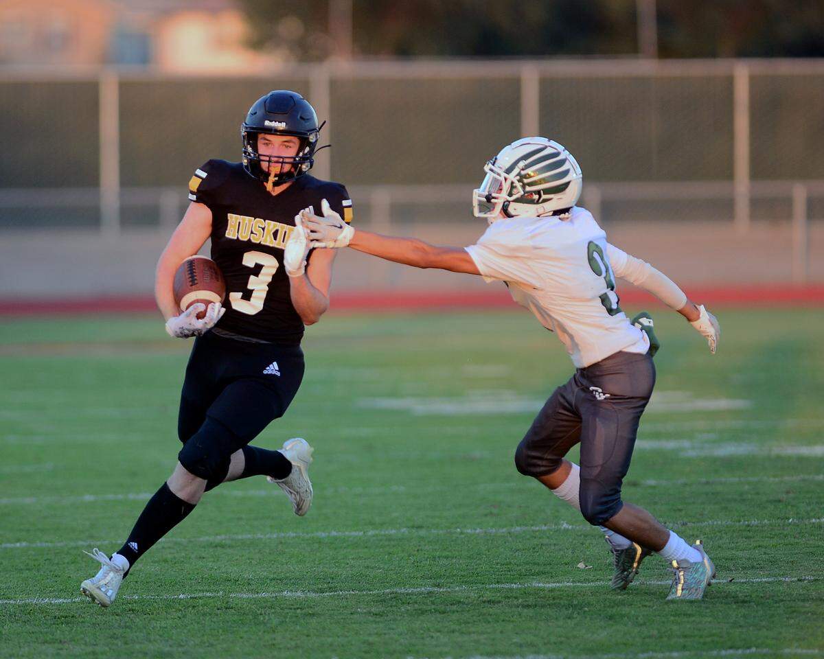 Hughsons Ben Lighthall reaches the edge to get around a Central Valley defender during a game between Hughson High School and Central Valley High School at Hughson High School in Hughson California on August 25, 2023.