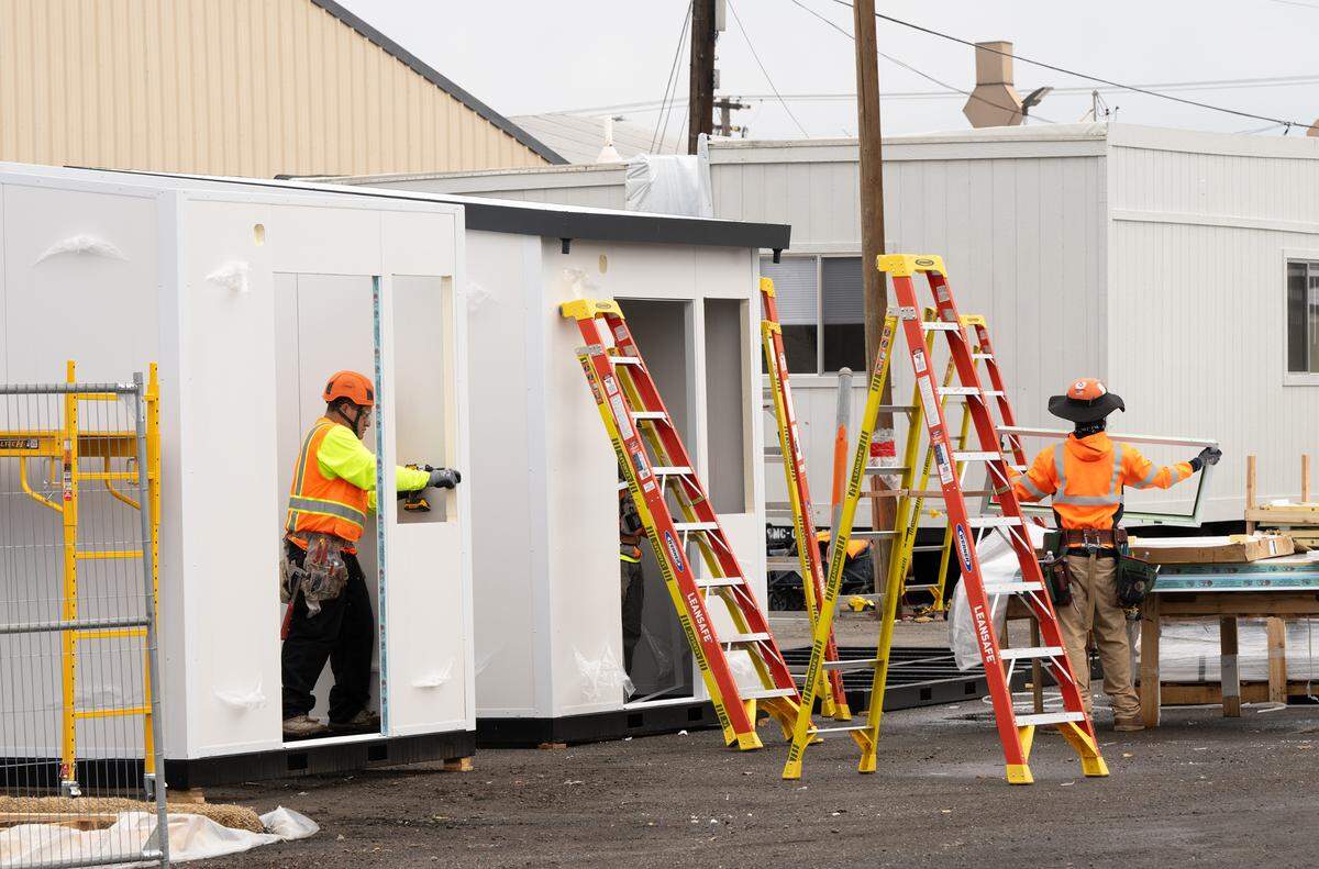 Workers build tiny homes as part of the new 42-unit bridge housing, Dignity Village, on 9th Street in Modesto, Tuesday, Nov. 26, 2024.