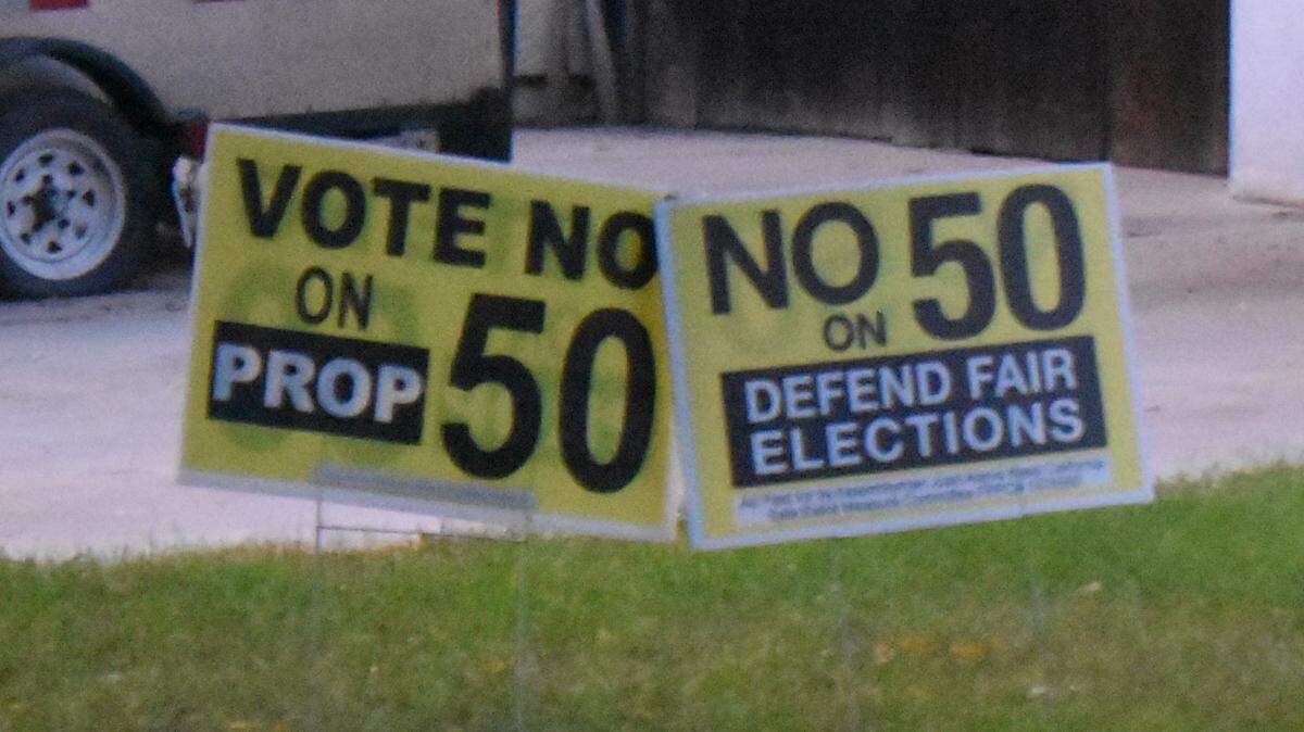 Proposition 50 signs stand in the yard of a home on East Union Avenue in Modesto on Oct. 22, 2025.