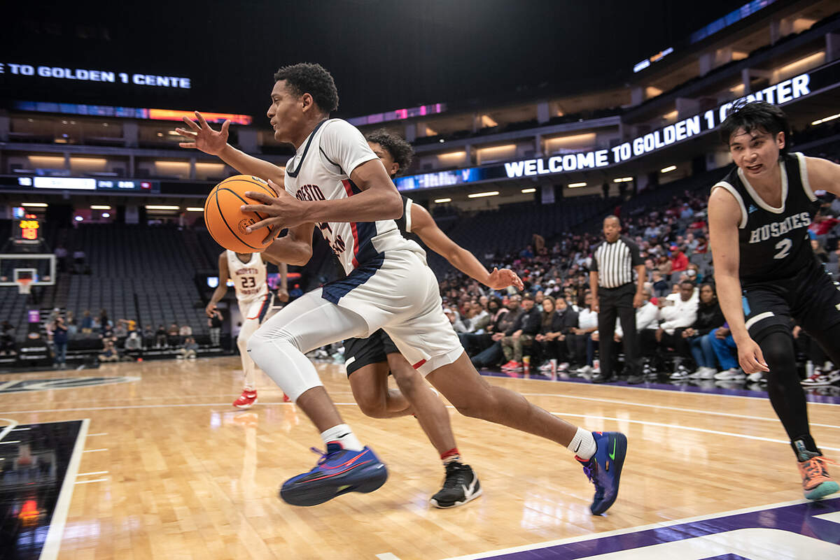 Modesto Christian’s Jamari Phillips drives along the baseline past Sheldon defenders in the Sac-Joaquin Section Division 1 boys basketball championship game at the Golden 1 Center in Sacramento, Calif., on Saturday, Feb. 26, 2022. Modesto Christian won the game 52-42.