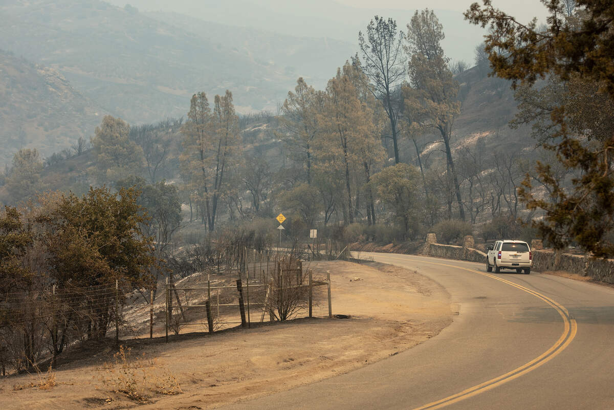An emergency vehicle drives past Frank Raines Park along Del Puerto Canyon Road near Patterson, Calif., on Thursday, August 20, 2020.