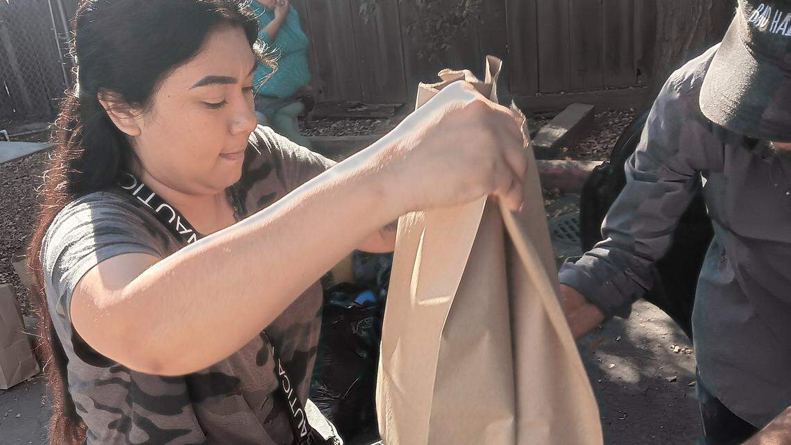 Volunteer Griselda Lara distributes food Thursday, Oct. 5, 2023, at the Food Initiative of Greater Stanislaus, formerly Inter-Faith Ministries of Greater Modesto. FIGS is going mobile with its food pantry to eventually have its trucks make 42 stops each month at locations across the county, including Modesto, Turlock, Waterford and Patterson.