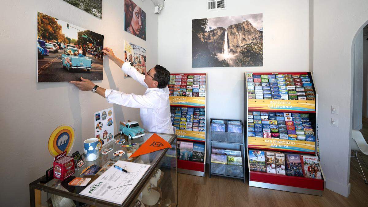 Visit Modesto CEO Todd Aaronson adjusts a photo on the wall of the new welcome center in Modesto, Friday, July 18, 2025. The Stanislaus Arts Council Gallery and Visit Modesto now share space at the gallery’s J Street location.