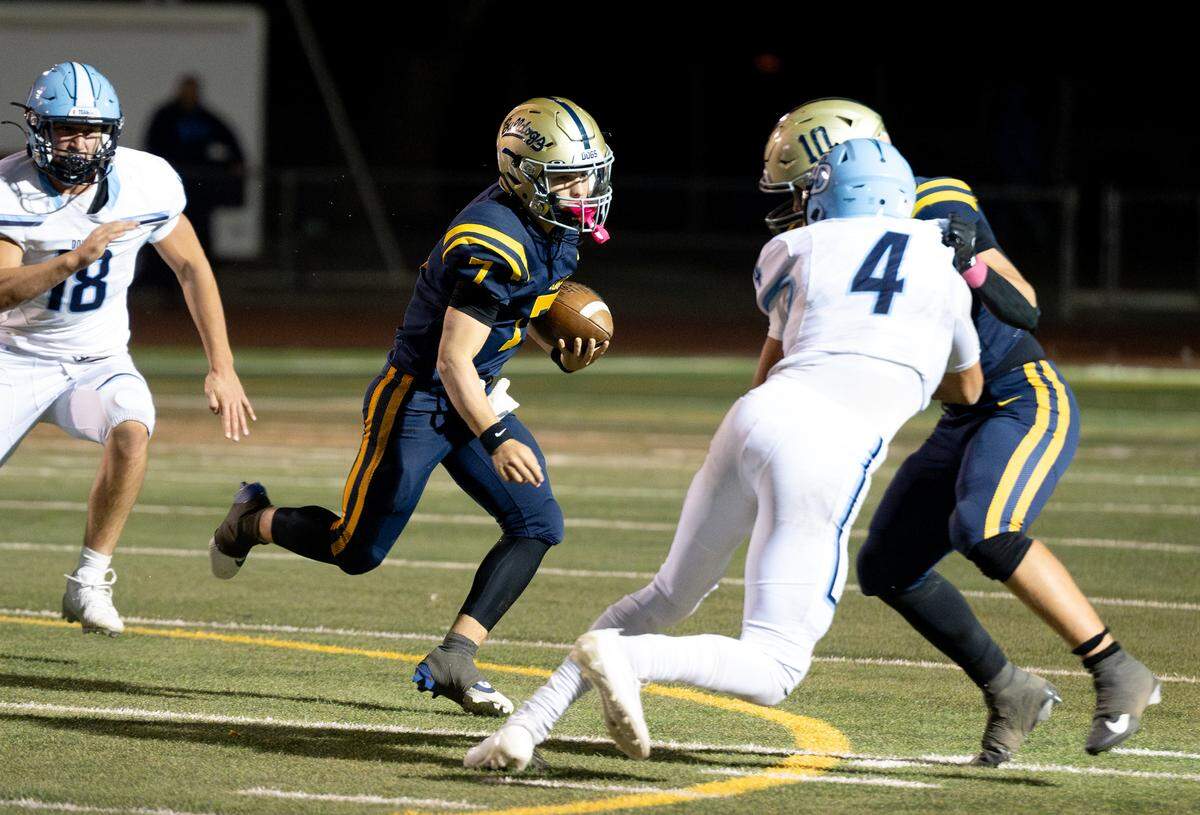 Turlock quarterback Scout Silva runs the ball to the outside during the Central California Athletic League game with Downey at Turlock High School in Turlock, Friday, Oct. 18, 2024.