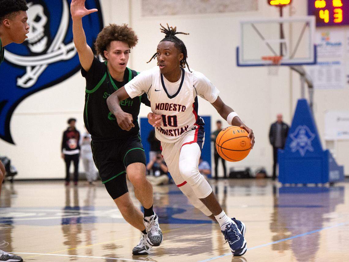 Modesto Christian’s BJ Davis advances the ball as St. Joseph’s Luis Marin defends during the NorCal Open Division championship game at Modesto Junior College in Modesto, Calif., Tuesday, March 7, 2023.