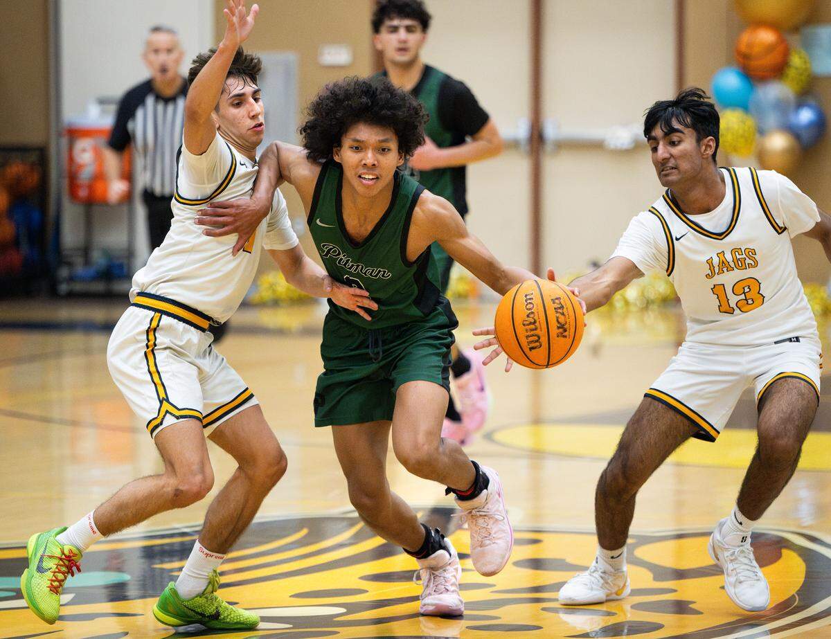 Pitman’s Cole Martin fights off Gregori’s Rajan Sandhu, right, and Kaleb Smith, left, during the Central California Athletic League game at Gregori High School in Modesto, Wednesday, Feb. 12, 2025.