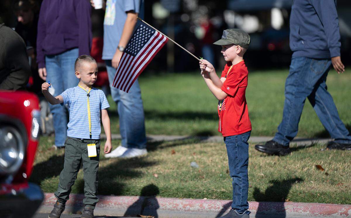 Brothers Derek Roberts, 7, and Cole Roberts, 5, watch the Modesto Veterans Day Parade in Modesto, Calif., Saturday, Nov. 11, 2023.
