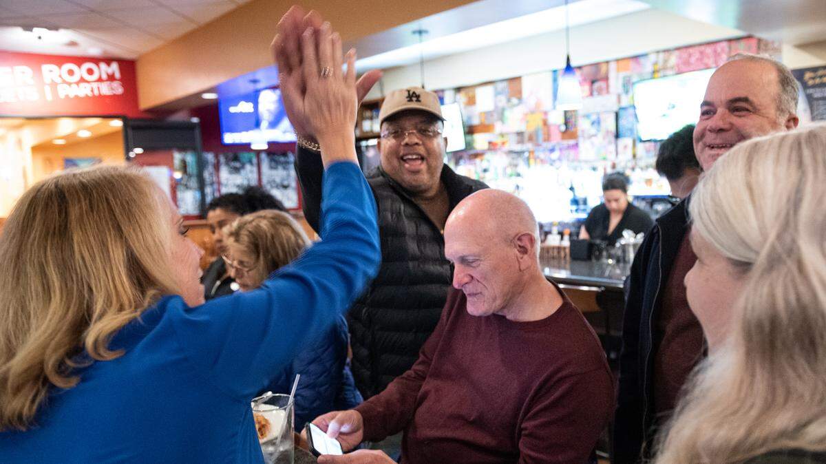 Modesto Schools superintendent Sara Noguchi, left, and board member John Ervin III, celebrate early results for Measure L, with board member Chad Brown, middle, and other supporters at Fuzio restaurant in Modesto Calif., Tuesday, Nov. 8, 2022.