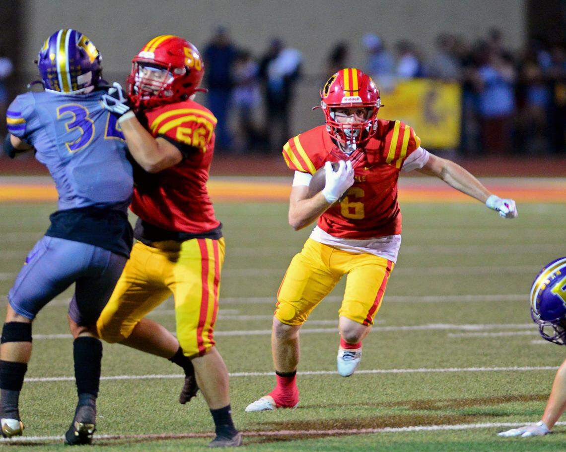 Oakdale running back Chase Lopez (6) runs behind a blocker during a game between Oakdale and Escalon at Oakdale High School in Oakdale, California, on September 15, 2023.