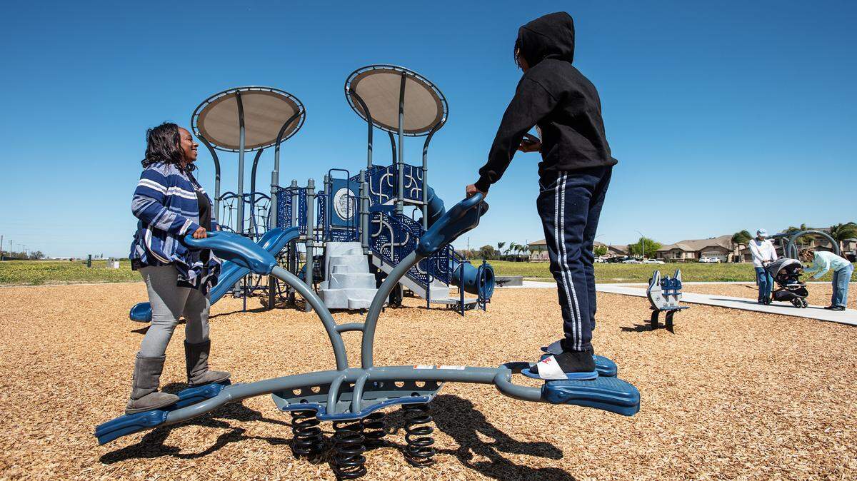 Cheri Thomas-Stevens and her son Chaun, 16, ride the teeter totter at Eastgate Park in Ceres, Calif., on Tuesday, March 23, 2021. The Ceres City Council voted Monday on renaming the park after Guillermo Ochoa, the city’s first Latino council member.