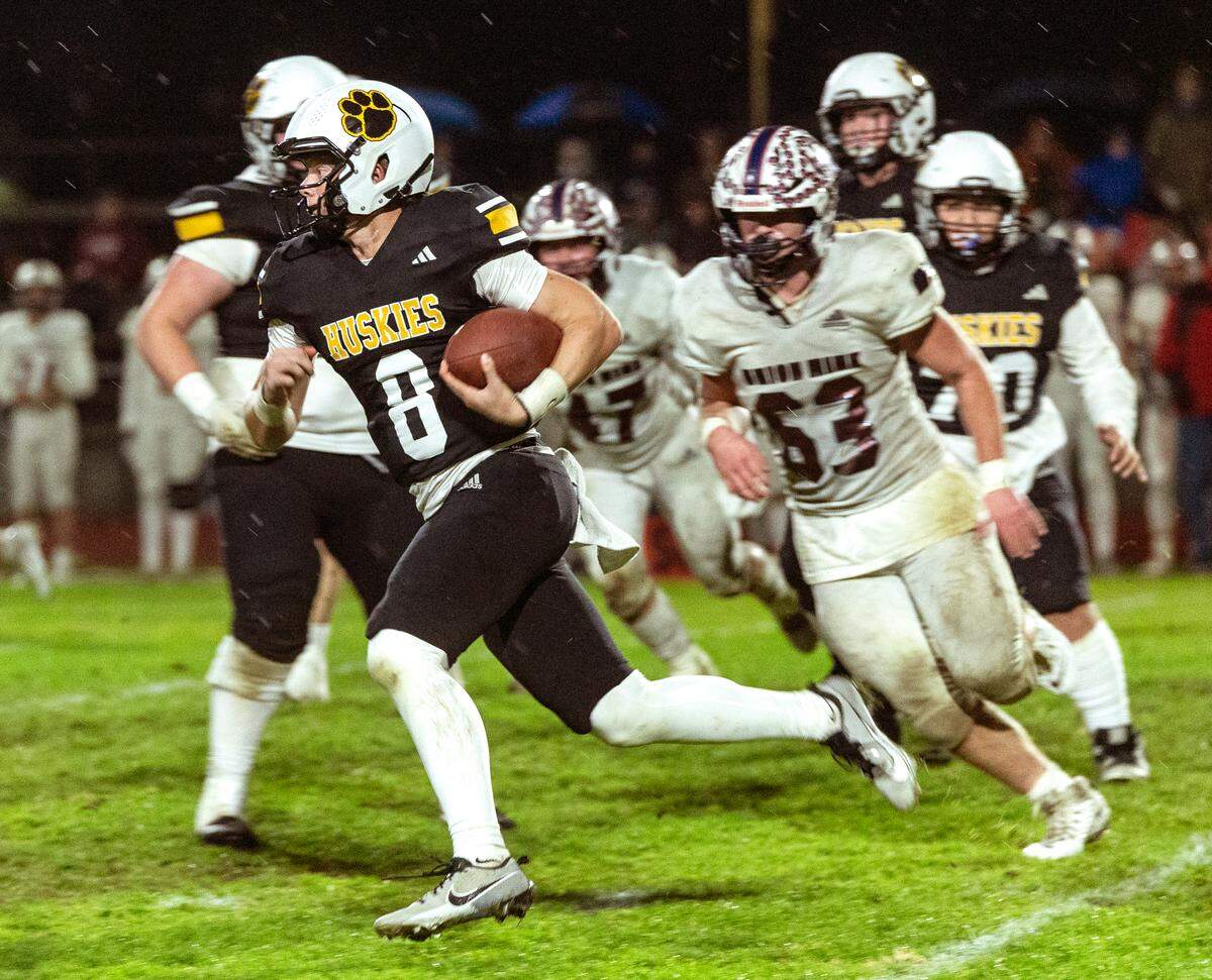 Quarterback, Robert McDaniel, 8, of Hughson High looks upfield during the Sac-Joaquin Section Division V Semifinals against Union Mine on at Hughson High School on Friday, Nov. 22, 2024.