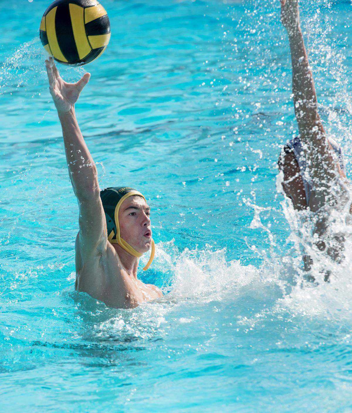 Davis’ Rhett Van Horn lobs the ball over a South Eugene Oregon defender for a score during the DeLong Water Polo Tournament game with South Eugene Oregon at Enochs High School in Modesto, Ca., on Friday, Oct. 19, 2018. South Eugene Oregon won the game 16-4.