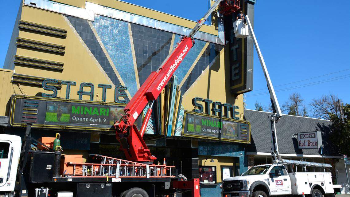 Workers remove neon in the State Theatre sign in Modesto, Calif. March 26, 2021.