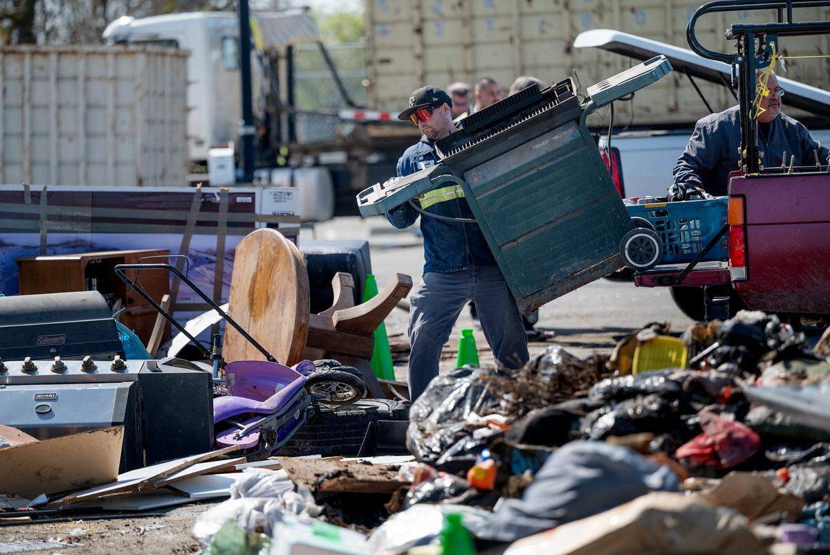 Bertolotti worker Jerald Chancey unloads a junk grill during Modesto’s “drive up, drop off” refuse collection event at John Thurman Field in Modesto, Calif., Saturday, March 25, 2023.