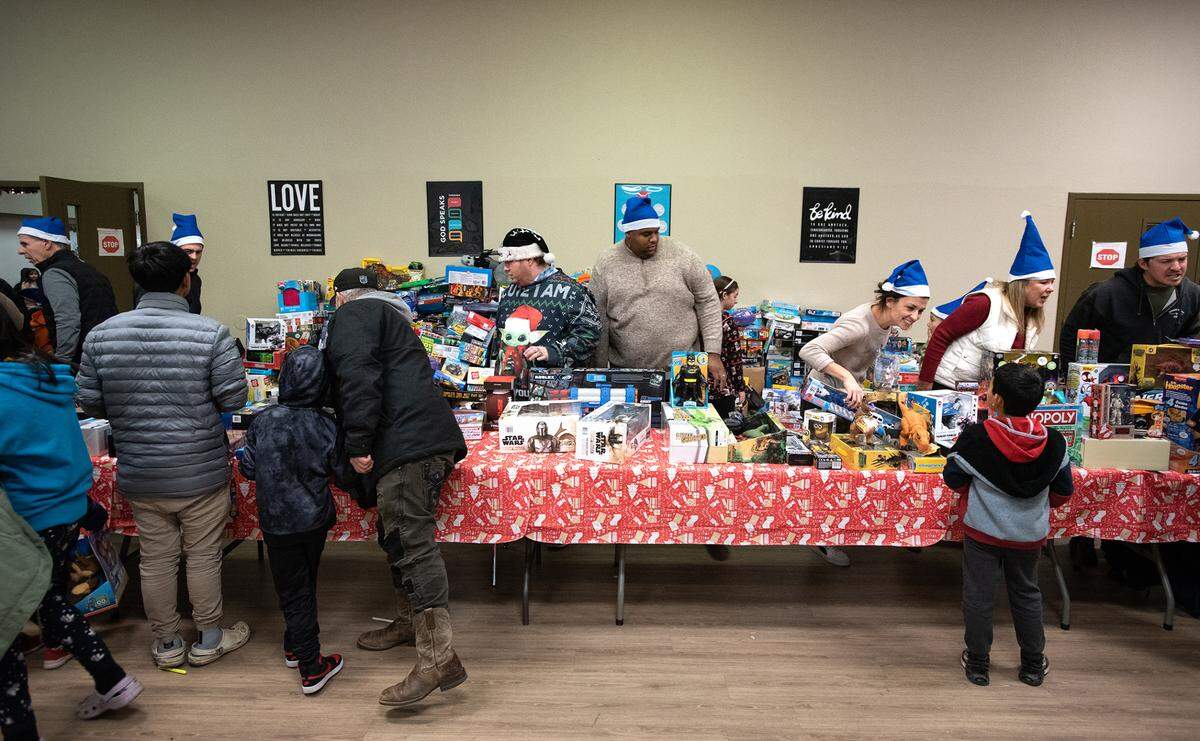 Volunteers give out toys and other gifts during Modesto Gospel Mission’s annual Christmas gathering in Modesto, Calif., Friday, Dec. 23, 2022.