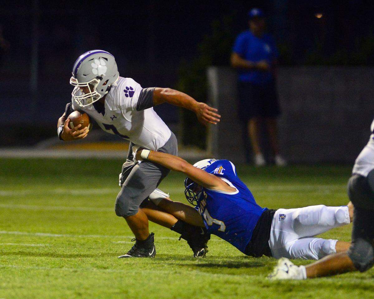Denair running back Isaac Villa Martinez is held back by an RC defender during a game between Ripon Christian and Denair at Ripon Christian High School in Ripon California on September 16, 2022.