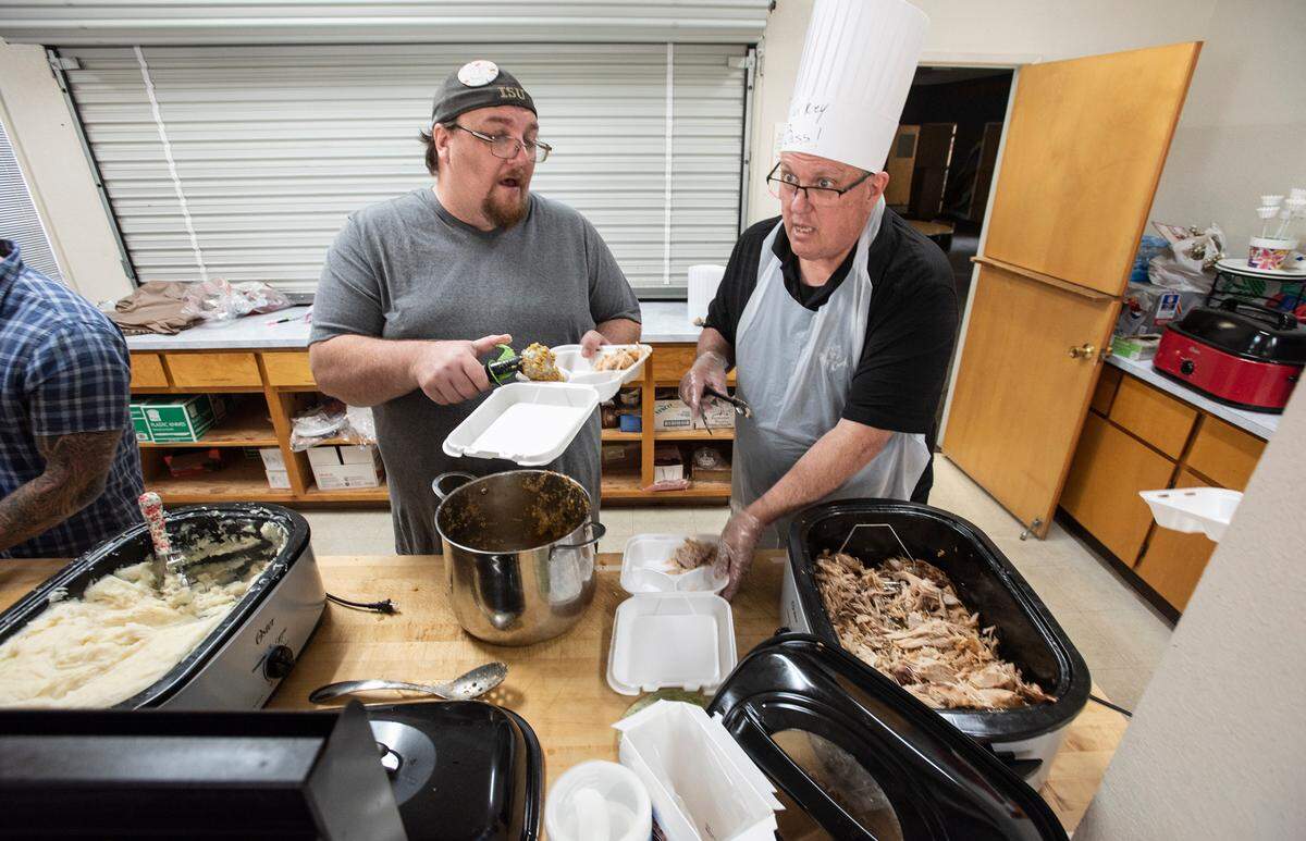 David Baiocchi, right, and Steven Jobe, left, package turkey dinners Waterford Ministerial Association hosted its seventh annual Community Thanksgiving Dinner in Waterford, Calif., on Thursday, Nov. 25, 2021. Meals were picked up in cars only due to COVID-19 precautions.