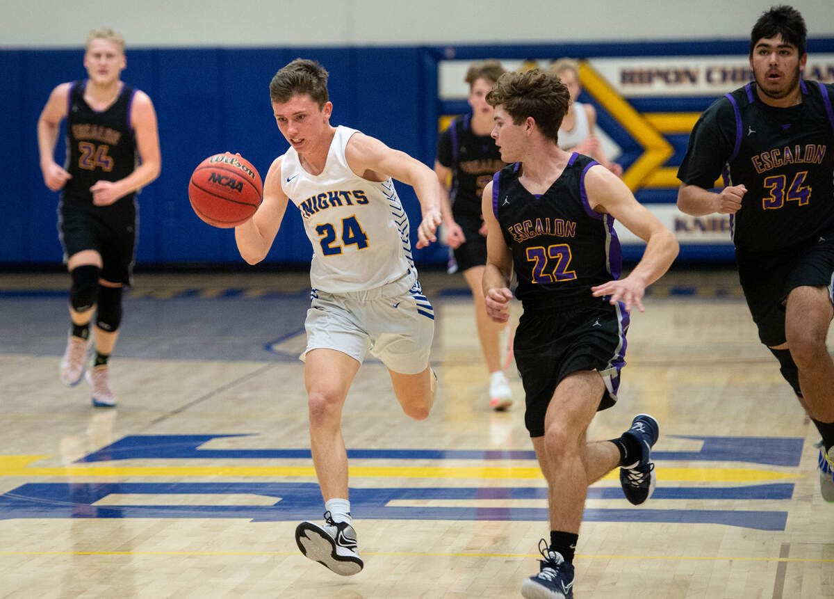 Ripon Christian’s Derek Van Elderen advances the ball as Escalon’s Ben Fletcher guards during the Trans Valley League game at Ripon Christian High School in Ripon, Calif., on Friday, Jan. 7, 2022. Ripon Christian won the game 61-53.