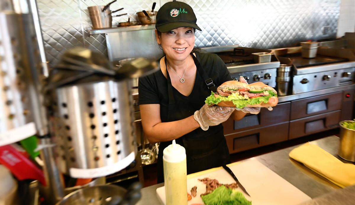 Owner Tina Tien holds a banh-mi sandwiche at Pho Mex restaurant in Modesto, Calif., on Thursday, June, 23, 2022.