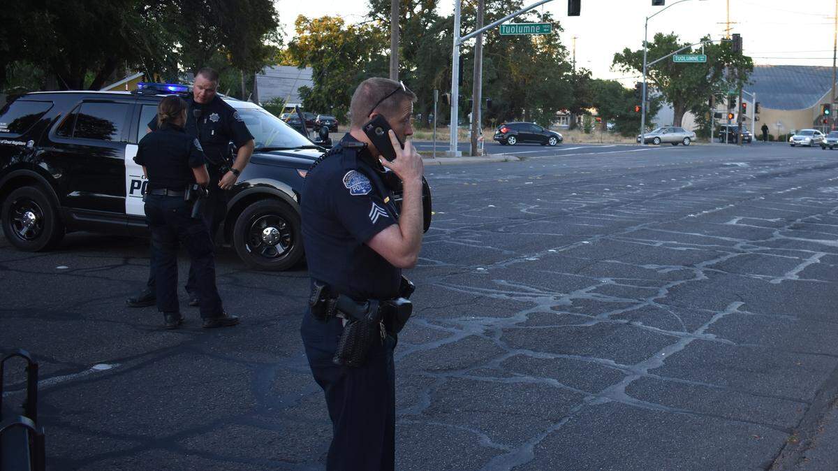 Modesto police Sgt. Jake Keiser, at the scene of a vehicle-vs.-pedestrian hit-and-run collision on Paradise Road on Tuesday morning, gets a call on the condition of the victim.