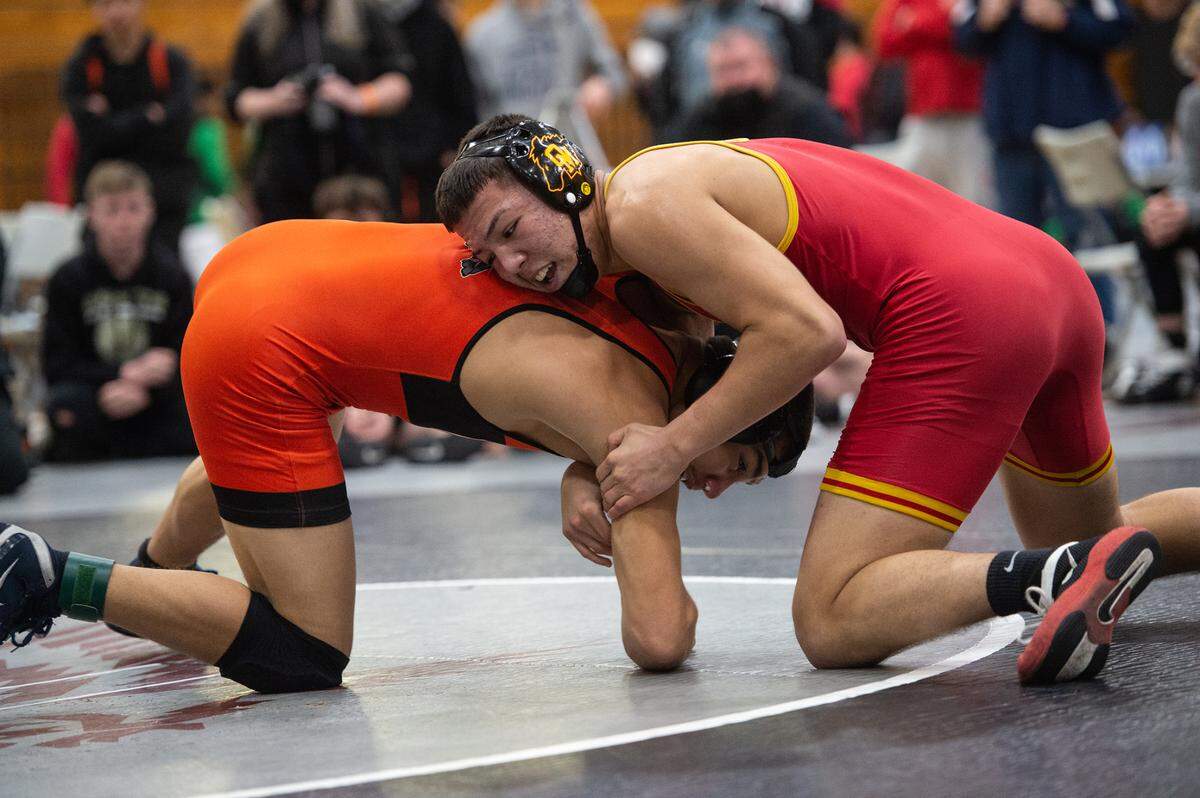 Oakdale’s Ceasar Garza, red, wrestles Vacaville’s Thomas Sandoval in the 170-pound match during the CIF Sac-Joaquin Section Wresting Team Duals Championships at Natomas High School in Sacramento, Calif., on Saturday, Jan. 29, 2022. Vacaville won the DI championship 41-19.