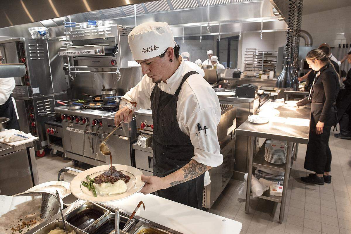 Cook Adrian Hernandez prepares steak n’ potatoes during preview night at the new Fina restaurant in Ripon, Calif., Friday, Aug. 2, 2019.