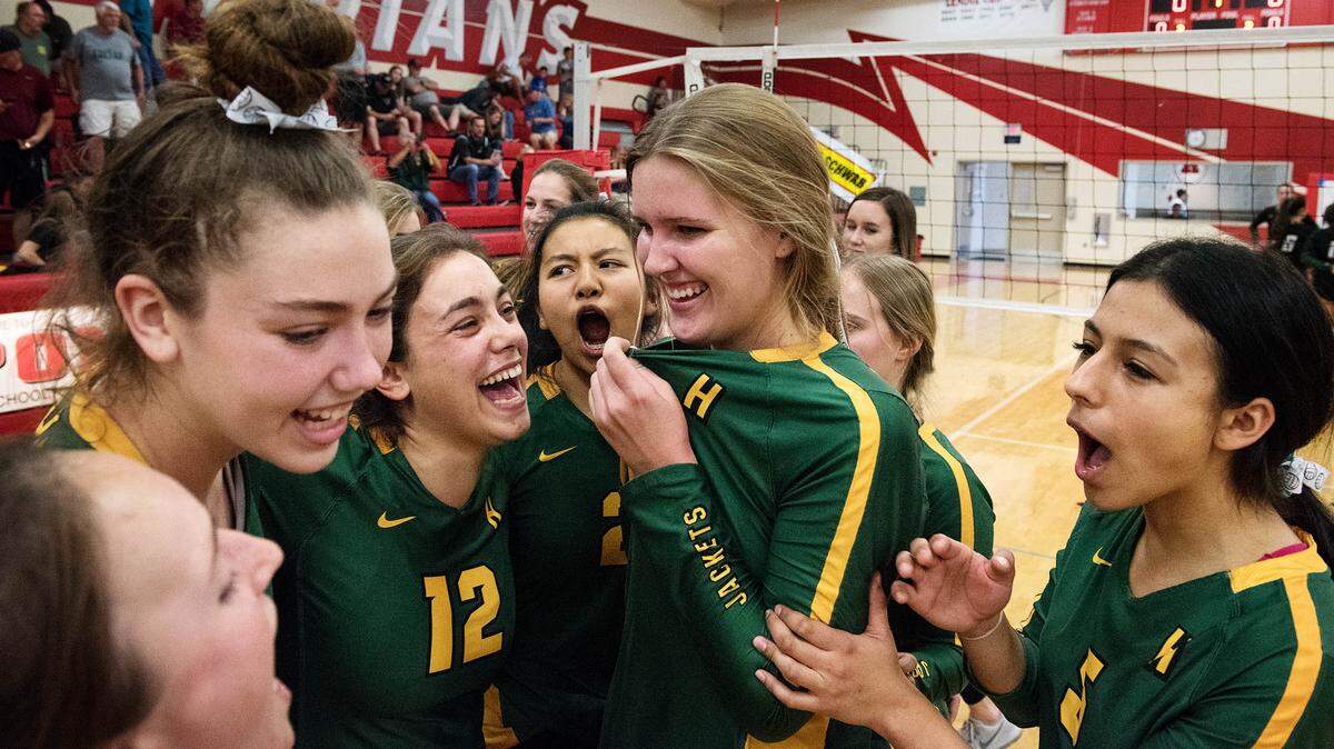 Hilmar players Olivia Peterson, middle, Makayla Fontes (12), Alondra Huerta, right, and Mikela Labno, left, celebrate their 3-0 section title victory over Colfax with their teammates in Ripon, Calif., Saturday, Nov. 3, 2018.