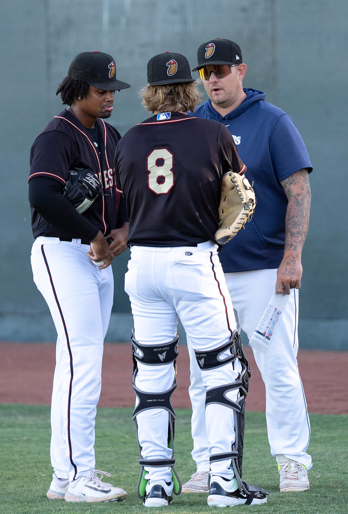 Modesto Nuts pitching coach Jake Witt talks with starting pitcher Christian Little and catcher Connor Dykstra before a game against the Inland Empire 66ers on Wednesday, Aug. 13, 2025.