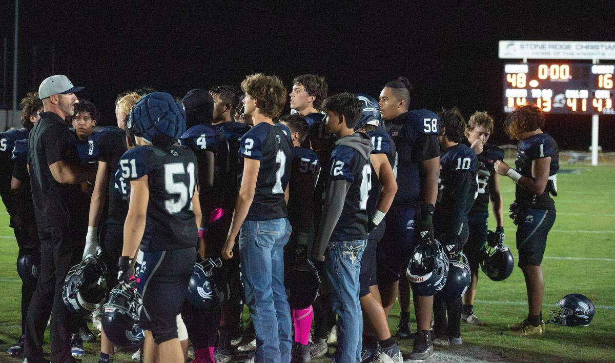 Stone Ridge Christian players huddle with head coach Anthony De Jager after their 48-16 homecoming win over Waterford on Friday night in Merced.