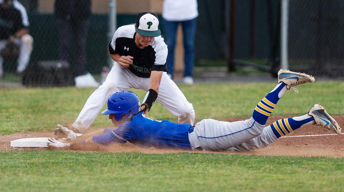 Turlock’s Gannon Evans beats the tag from pitman third baseman Karson Valenti for a triple in the seventh inning in the Central California Athletic League game with Pitman at Pitman High School in Turlock, Calif., on Thursday, April 14, 2022.