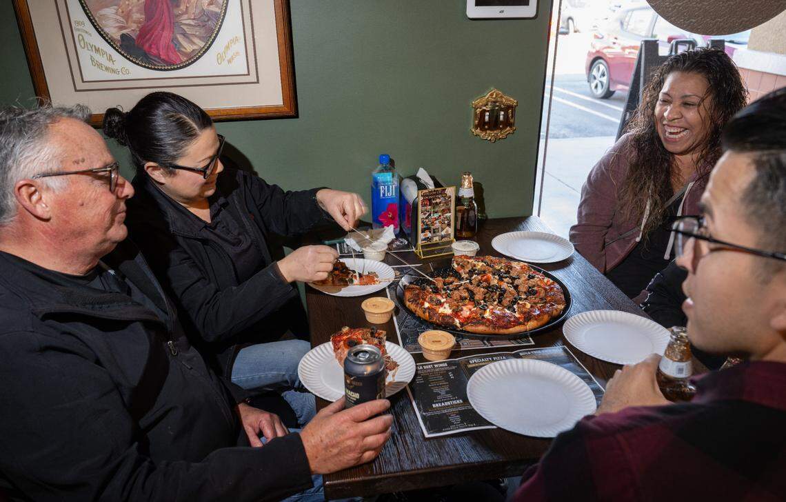 Customers Don Sahagun, left, Ana Jungkeit, second left, Anna Leggett, right, and friends enjoy the Digger specialty pizza at Gold Dust Pizza Express in Modesto, Thursday, Dec. 5, 2024.