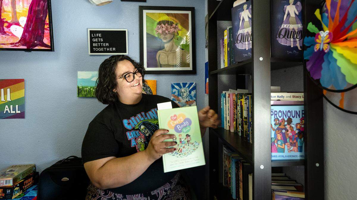 MoPride community organizer Veronica Ambrose shows the young adult book collection at the Central Valley Pride Center in Modesto, Calif., Thursday, Oct. 19, 2023.