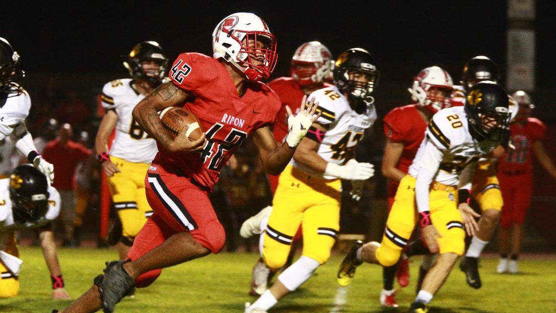 Derric Roy, 42, of Ripon High works his way upfield as Hughson High defense closes on Friday, Oct. 19, 2018, at Ripon, California.