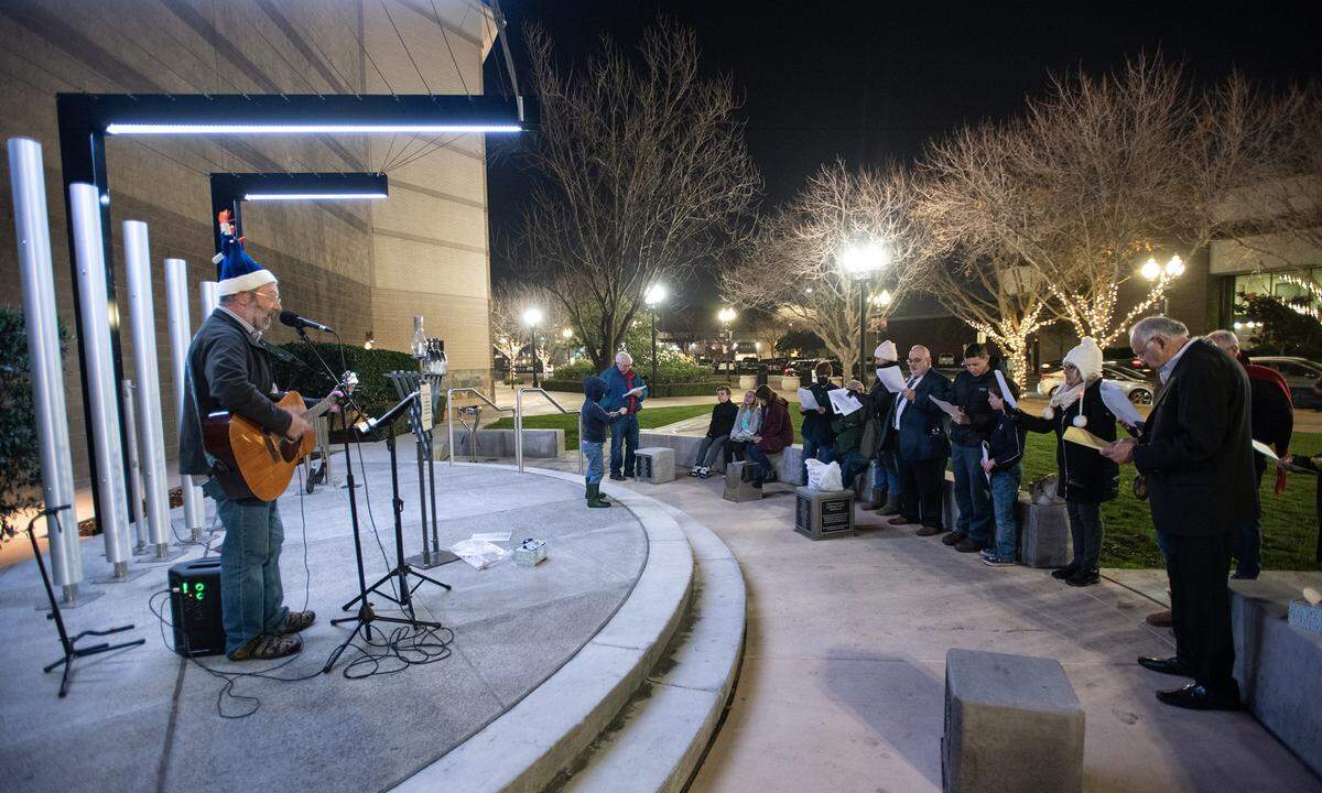 Congregation Beth Shalom Rabbi Shalom Bochner sings songs with a small group gathered at the Gallo Center for the Arts during a candle lighting on the third day of Hanukkah outside in Modesto, Calif., Tuesday, Dec. 20, 2022.