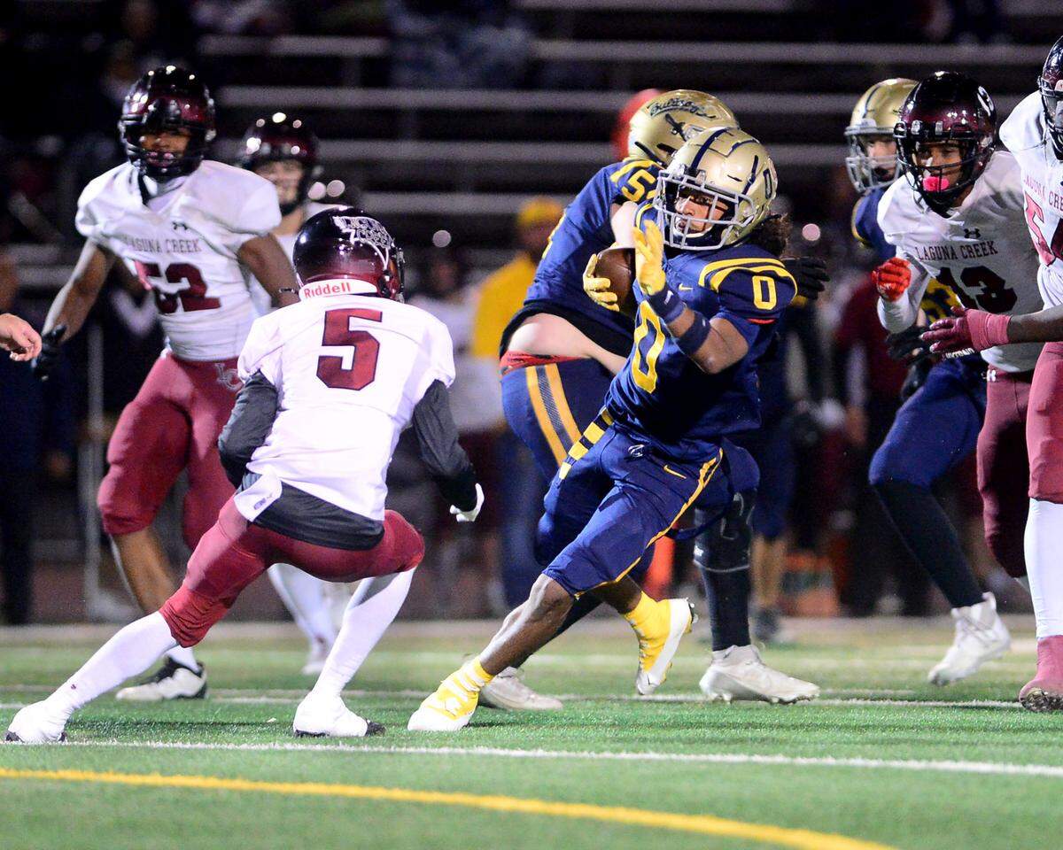 Turlock running back Jeremiah Stine (0) jukes a defender during a Division 1 CIF San-Joaquin Section playoff game between Turlock High School and Laguna Creek High School at Turlock High School in Turlock California on Nov. 8, 2024. Turlock won the game 48-12.