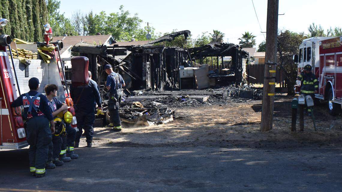 Denair and Keyes firefighters prepare to leave the scene of the house fire they extinguished on the 3500 block of Fresno Avenue in Denair on Sunday morning, May 30, 2021
