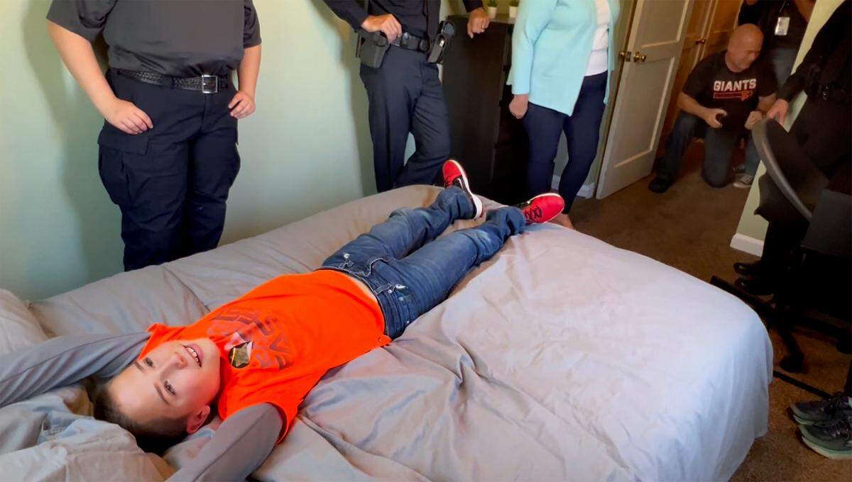 Dustin Tracy, 10, reacts to seeing his newly remodeled bedroom in Modesto, Calif., on Friday, June 3, 2022. Modesto police and other local law enforcement members remodeled six rooms for nine children in Modesto and Empire through 10K with a Cop and the Healthy Room Project.