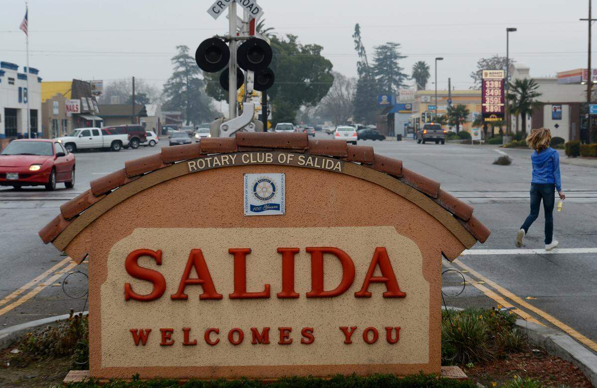 Traffic flows as a woman crosses Broadway Avenue in Salida in 2013.