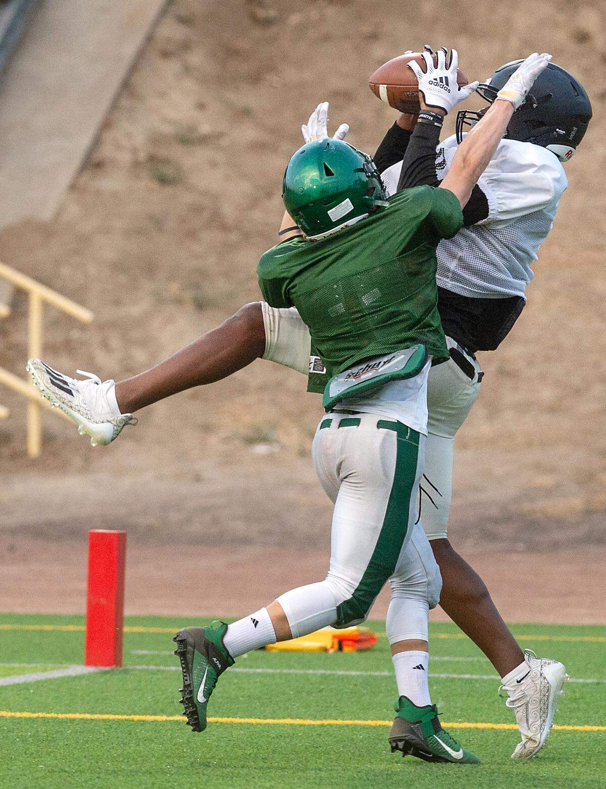 Enochs’ Kolawole Babalola makes a catch over a Sonora defender during a pre-season scrimmage at Downey High School in Modesto, Calif., on Friday, Aug. 13, 2021.