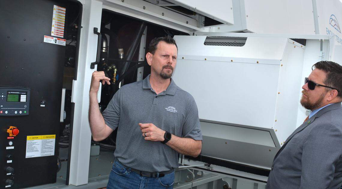 Greg Edwards, left, vice president for systems integration at Enchanted Rock, explains the emergency power plant it built to Assemblyman Juan Alanis in Modesto CA on June 3, 2024.