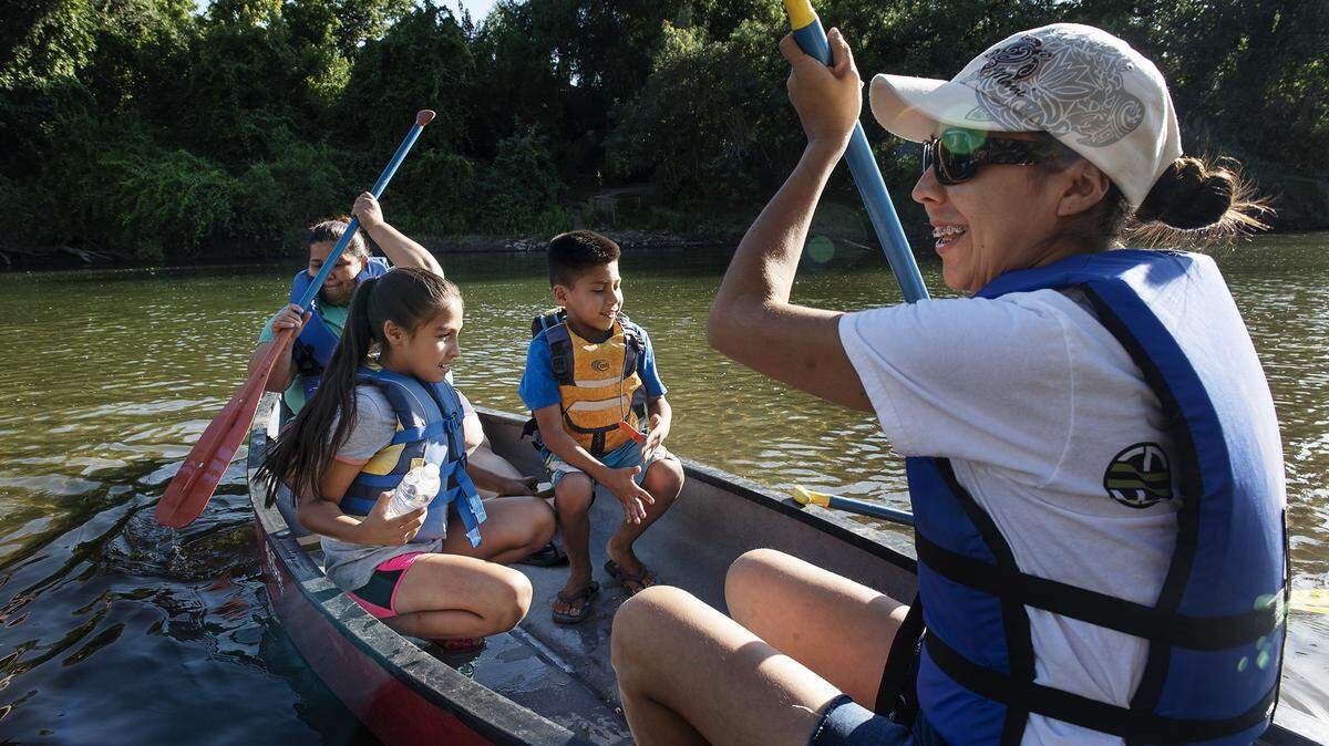 Marta Garcia, right, prepares to canoe on the Tuolumne ever with her children Monica Delgado, 8, and Ismael Delgado, 7, at Legion Park in Modesto, Calif., Thursday, August 1, 2019.